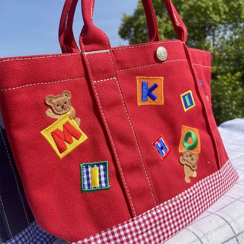 Handtasche – Karierter Bär aus Cartoon-Stickerei, leichte Canvas-Tasche mit großer Kapazität 342121 cm, Bento-Tasche
