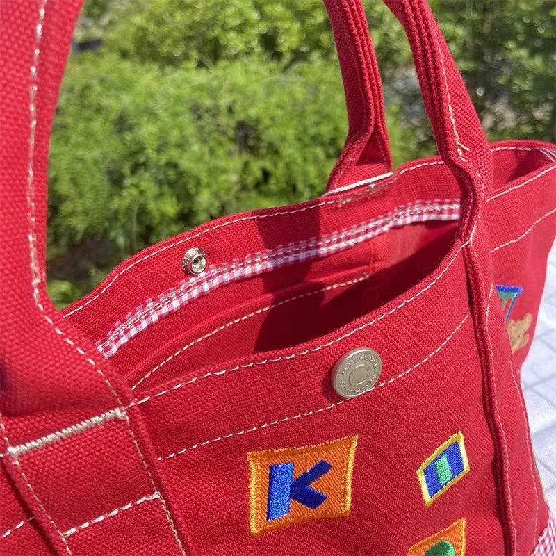 Handtasche – Karierter Bär aus Cartoon-Stickerei, leichte Canvas-Tasche mit großer Kapazität 342121 cm, Bento-Tasche